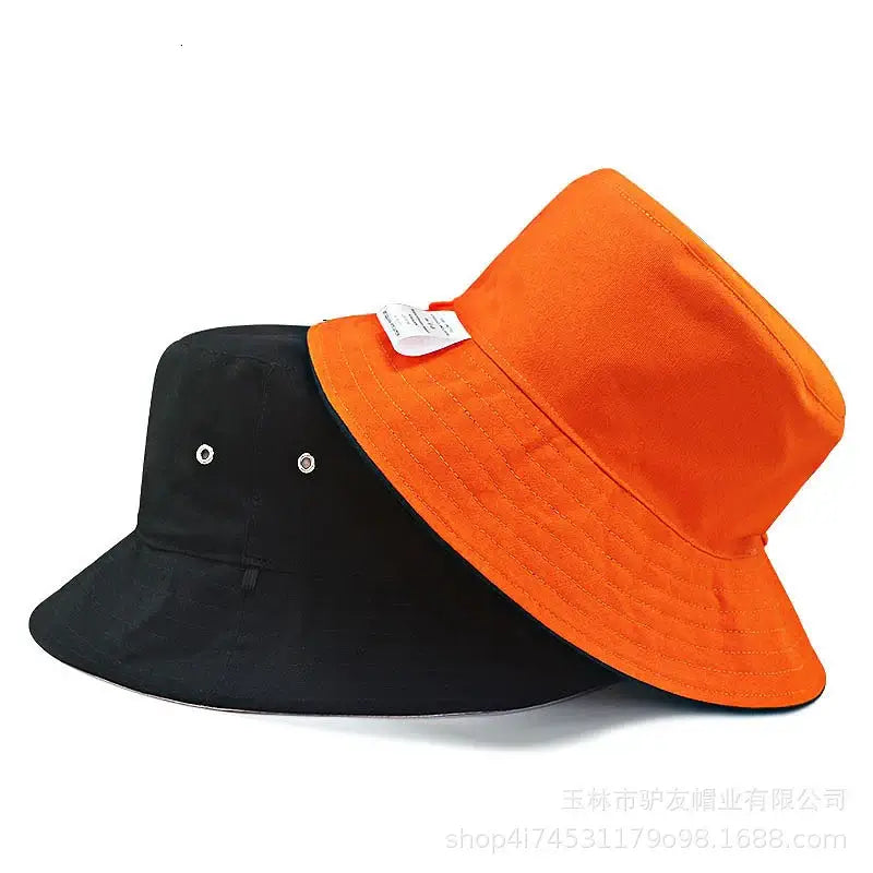 Unisex oversize cotton bucket hats in vibrant orange and black. Wide-brimmed design ensures stylish sun protection for summer adventures.