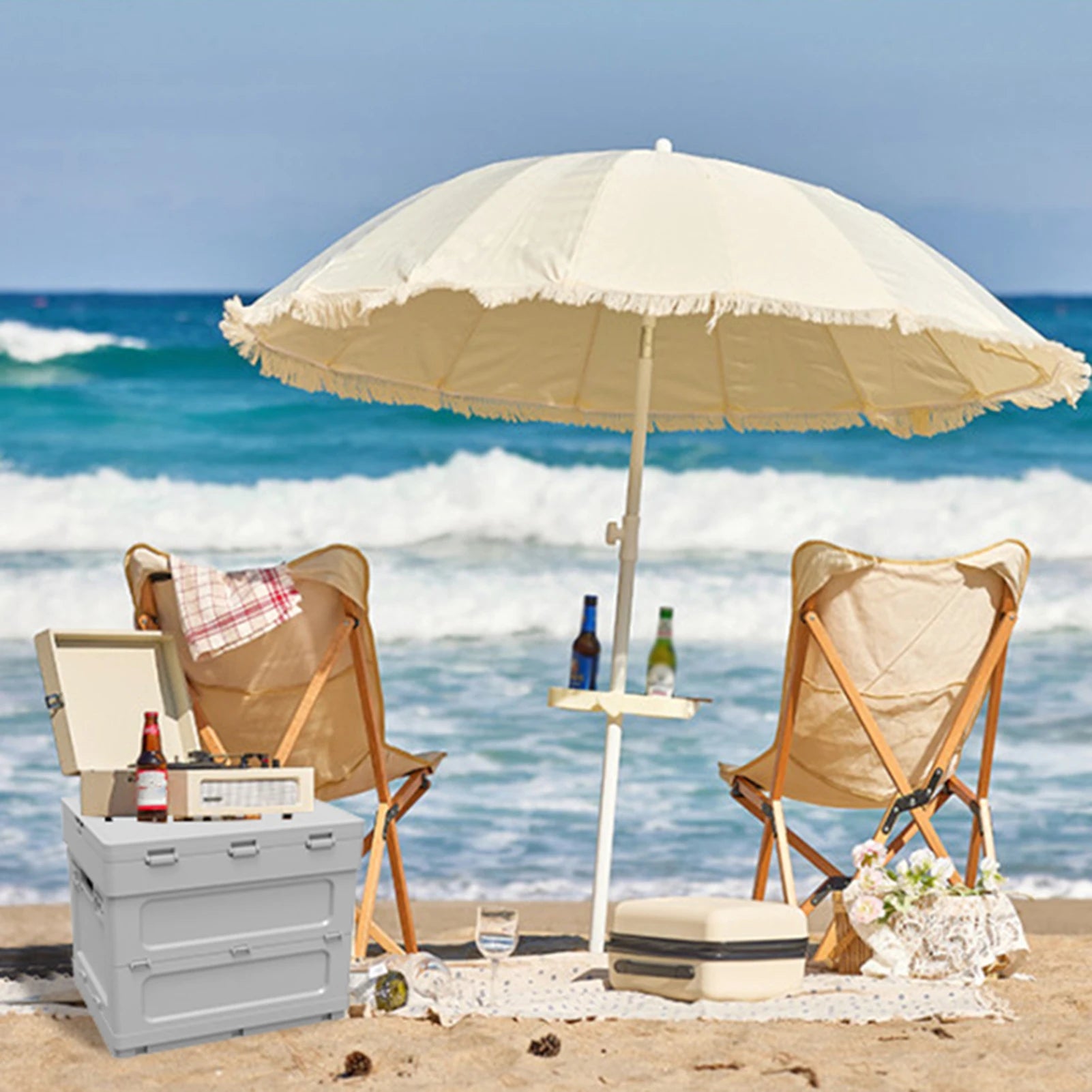 Portable picnic table with cooler feature on a beach setup. Ideal for outdoor seating, drinks, and storage under an umbrella.