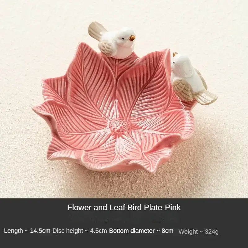 Pink flower-shaped ceramic jewelry tray with two bird figurines, labeled Flower and Leaf Bird Plate-Pink, for decorative storage.