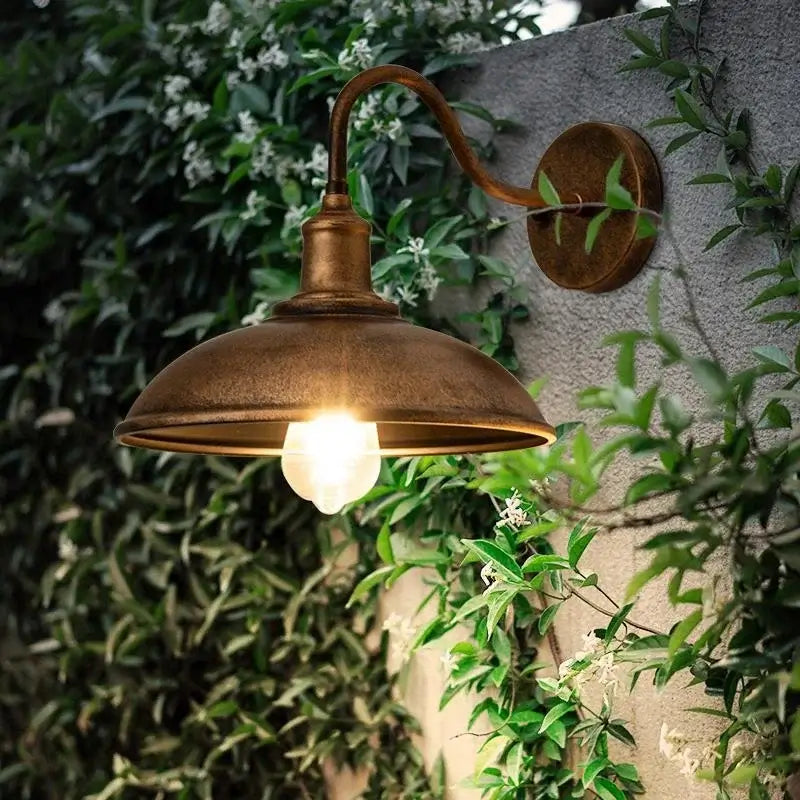 Retro Outdoor LED Wall Lamp - Waterproof Lighting mounted on a garden wall with lush greenery, ideal for villa or patio ambiance.