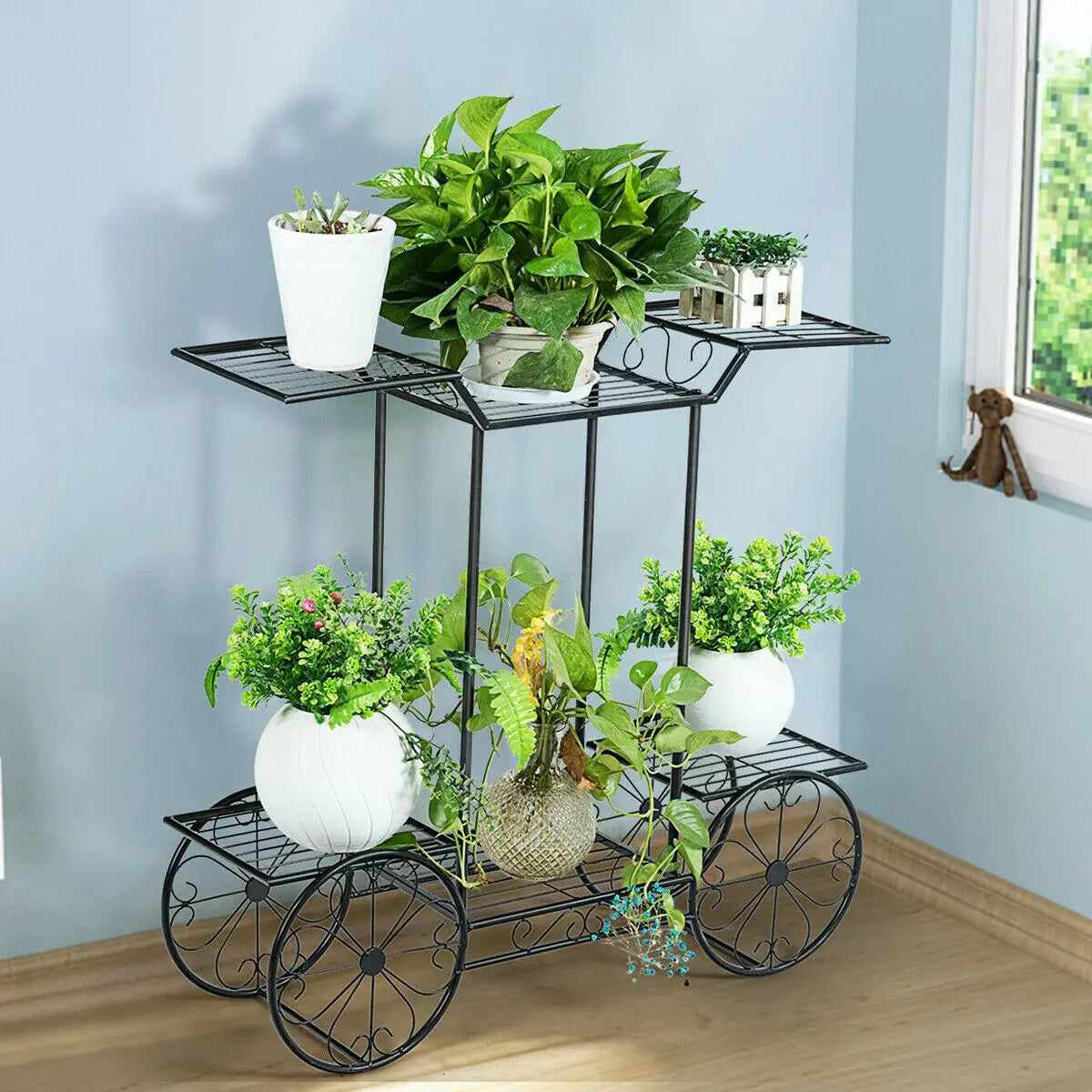 6 Tier Plant Holder Cart with vibrant green plants in white pots by a window. Durable iron frame adds charm to indoor garden spaces.