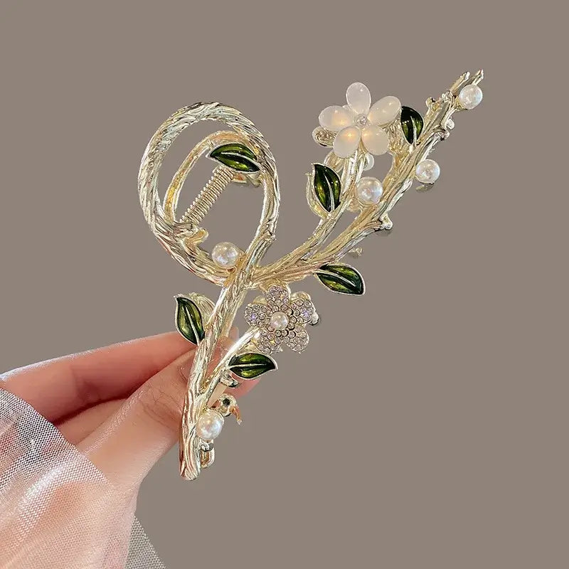 White floral ponytail hair clip with pearl and leaf accents, perfect for secure and decorative updos.