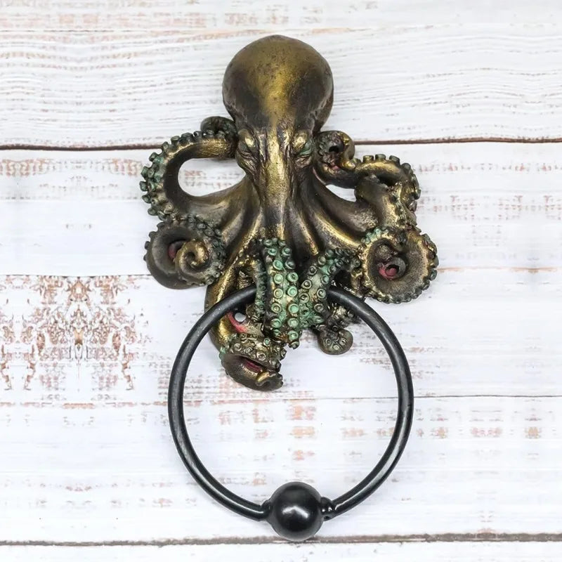 Front view of octopus skull resin door knocker on white wood background, highlighting gothic design with green tentacle accents and iron ring.