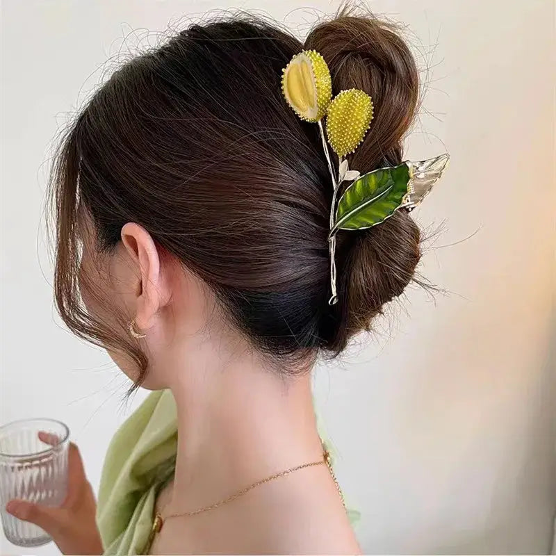 Yellow spiky flower ponytail hair clip with green leaves, offering strong grip and stylish hold for buns or ponytails.