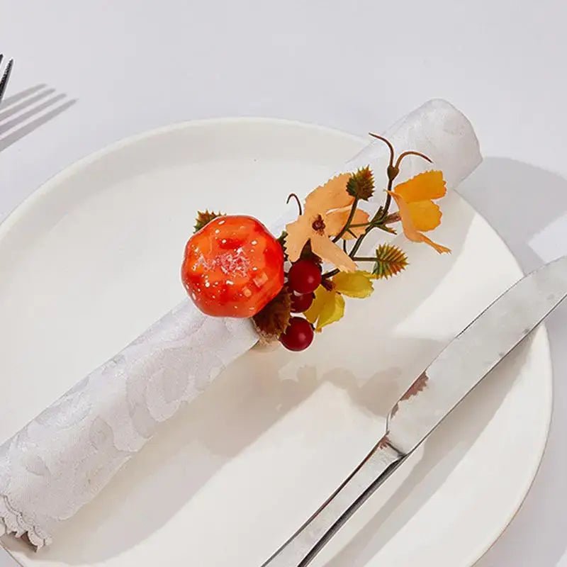 Elegant Halloween Pumpkin Napkin Ring with faux pumpkin, berries, and autumn leaves on a white napkin, perfect for seasonal dining decor.