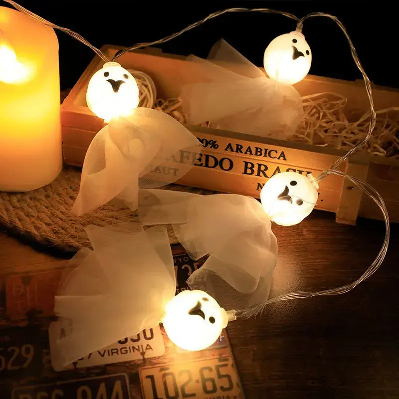 Ghost-shaped LED string lights with tulle fabric. Soft glow ideal for Halloween party or bedroom decor.