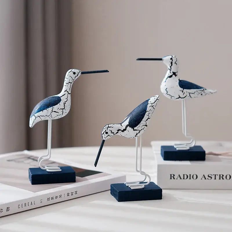 3pcs wooden seagull figurines in white and navy blue with rustic crackle finish, perfect for nautical coastal decor on tabletops or shelves.