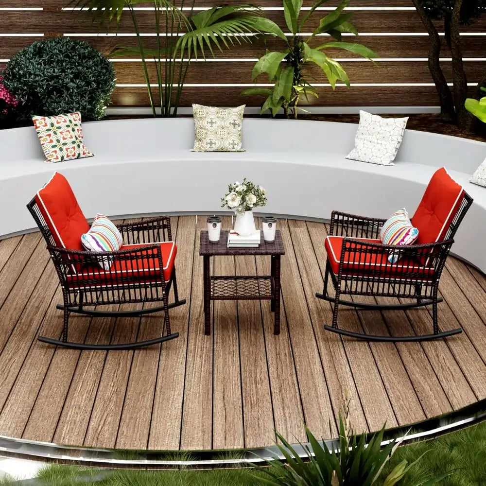 Durable rattan 3-piece patio rocking chair set with red cushions arranged on a wooden deck in a circular seating area.