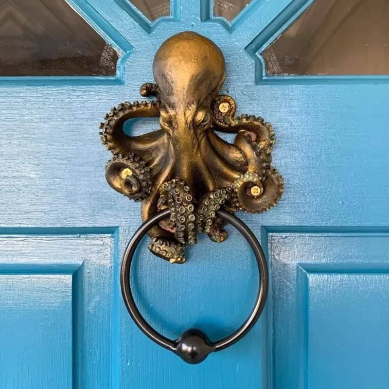 Octopus skull resin door knocker mounted on a blue door, featuring intricate tentacle details and a black cast iron ring for a gothic entryway accent.