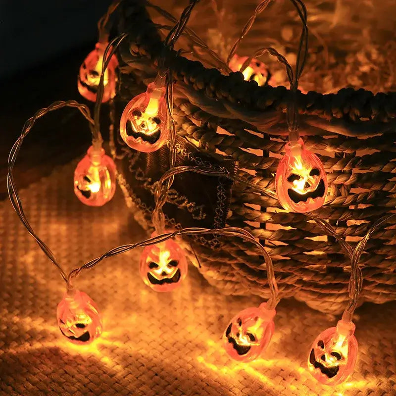 Acrylic pumpkin LED string lights glowing orange in a basket. Great for Halloween porch or indoor decor.