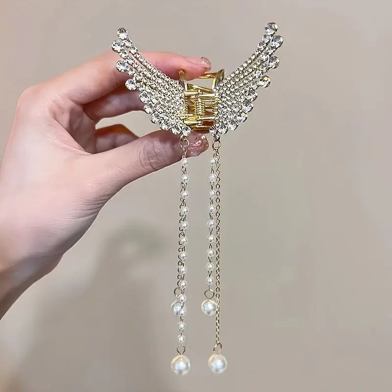 Crystal version of Women Butterfly Tassel Hair Clip held in hand. Sparkling rhinestones and pearl tassels create a luxurious hair accessory.