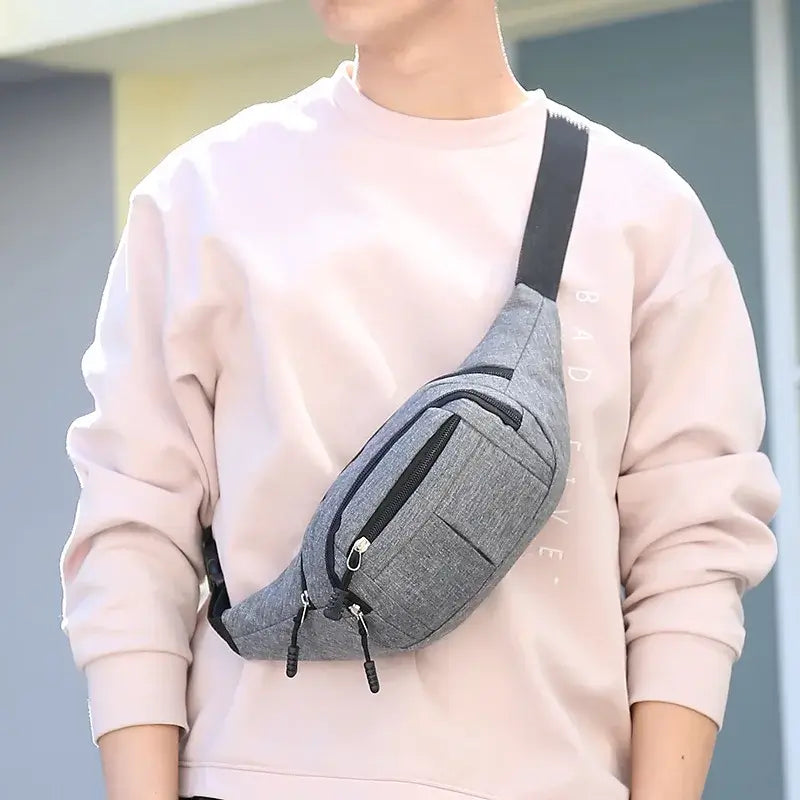 Man wearing gray fanny bag waist pack across chest, showcasing hands-free convenience for everyday activities.