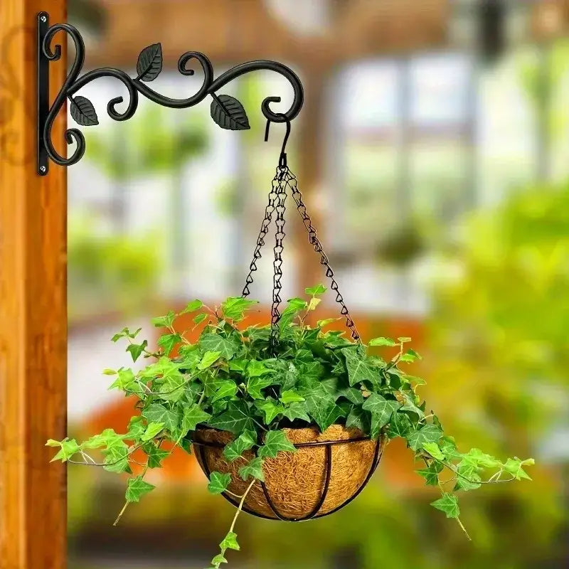 Rustic iron wall bracket mounted on wooden post, supporting a hanging planter basket with lush green ivy for garden decor.
